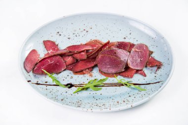 Beyaz arka plan üzerinde izole yeşil roka ile devekuşu basturma taze barışlar