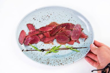 Beyaz arka plan üzerinde izole yeşil roka ile devekuşu basturma taze barışlar