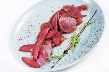 Beyaz arka plan üzerinde izole yeşil roka ile devekuşu basturma taze barışlar