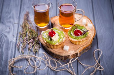 meyve pasta kreması, kivi ve vişne ile iki fincan çay wit