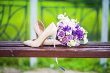 Kadın moda düğün ayakkabıları ile yeşil çim zemin üzerine pastel tonlarda zarif gelin buketi. Düğün detayları.