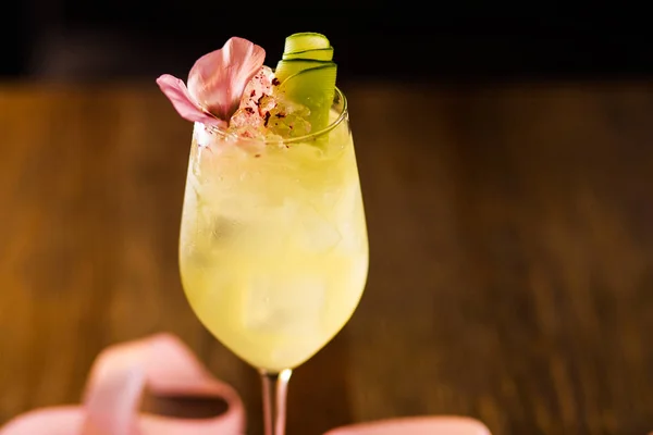 黄色酒精鸡尾酒与冰和粉红色丝带在餐馆 — 图库照片