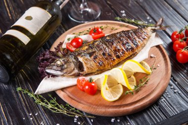 limon ve domates siyah arka plan üzerine kızarmış balık