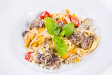 Dana eti, domates ve fesleğen izole beyaz makarna