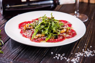 Carpaccio roka ve mantarlı beyaz plaka restoran