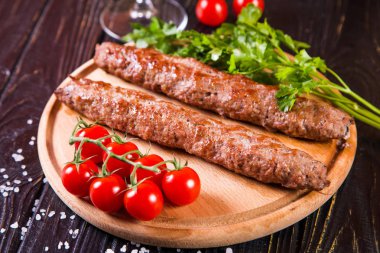 domates ve maydanoz siyah ahşap zemin üzerine sıcak kızarmış kebabı