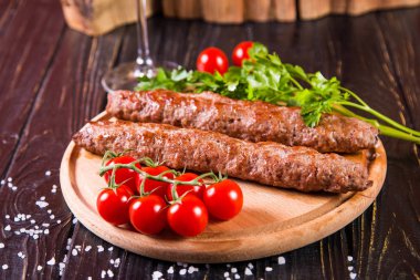 domates ve maydanoz siyah ahşap zemin üzerine sıcak kızarmış kebabı