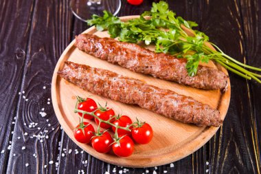 domates ve maydanoz siyah ahşap zemin üzerine sıcak kızarmış kebabı