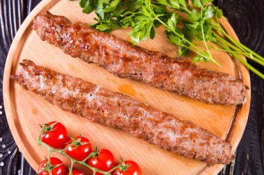 domates ve maydanoz siyah ahşap zemin üzerine sıcak kızarmış kebabı