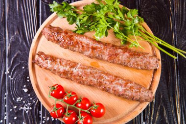 domates ve maydanoz siyah ahşap zemin üzerine sıcak kızarmış kebabı