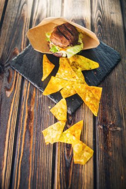 ahşap arka plan üzerinde patates cipsi ile sıcak taze burger
