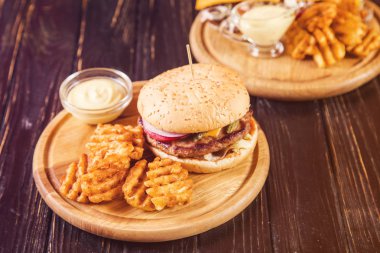 sıcak taze burger patates cipsi ve ahşap zemin üzerine hardal