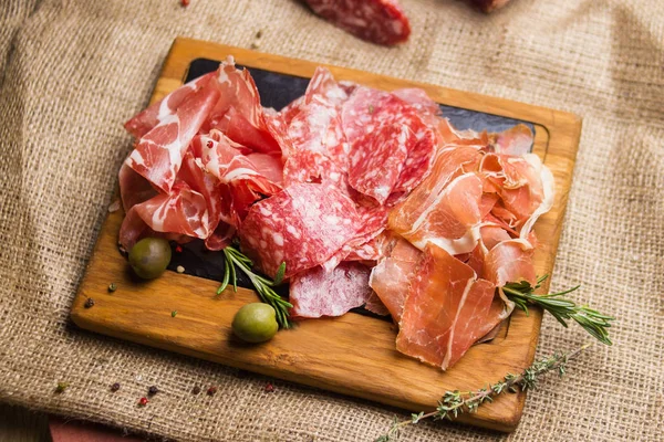 stock image set with ham,sausage and fresh rosemary isolated on wooden