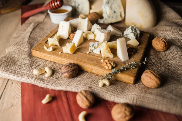 cheese plate with honey, and nuts isolated on wooden