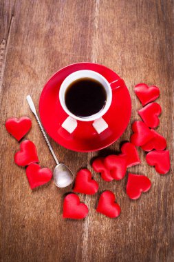 Sevgililer günü için sabah kahvaltısı. Bir fincan kahve ve kırmızı kalplerin eski ahşap arka plan üstten görünüm.