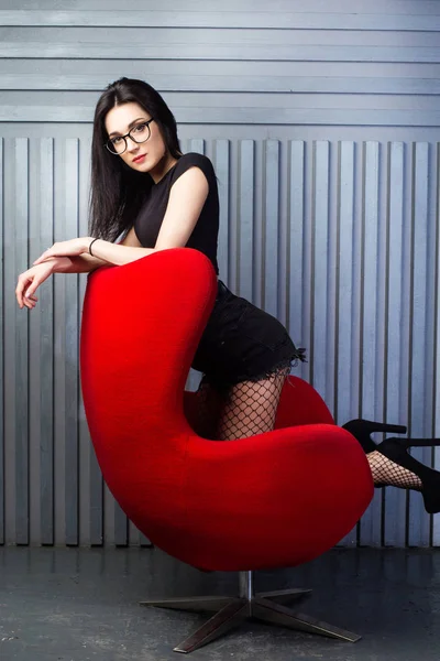 Chica joven en silla roja —  Fotos de Stock