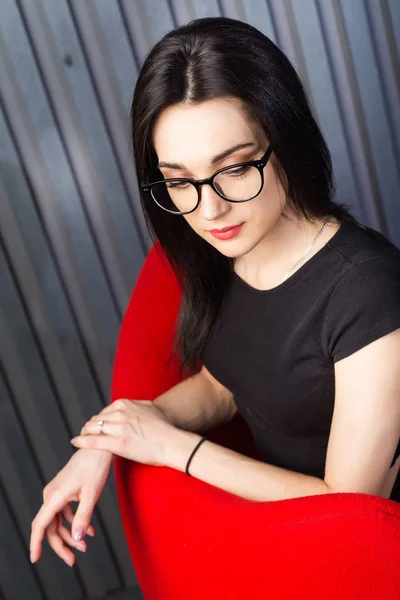 Young girl in red chair — 스톡 사진