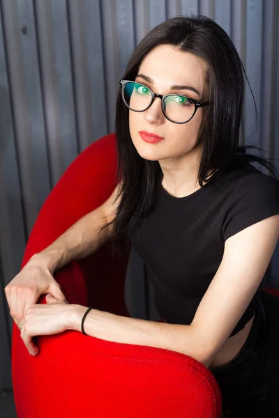 Young girl in red chair — 스톡 사진