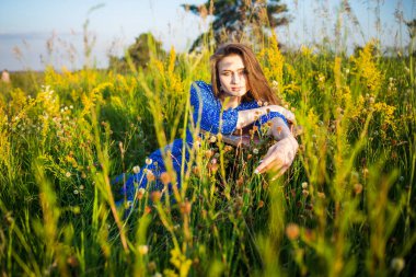 Açık havada, tarlada mavi elbiseli güzel bir kızın portresi.