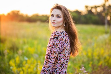 Renkli elbiseli güzel bir kızın portresi. Açık havada, tarlada.