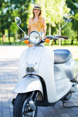 Sarı elbiseli güzel Avrupalı kız sabah parkında scooterlı.