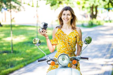 Sarı elbiseli güzel Avrupalı kız. Sabah parkında eski bir kamera var.