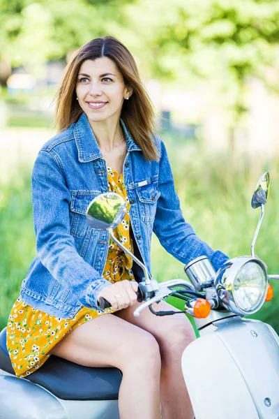 kot ceketli, motorlu scooterlı güzel bir kız.