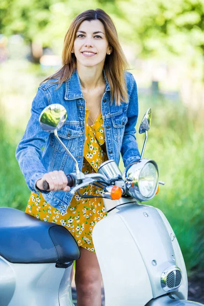 kot ceketli, motorlu scooterlı güzel bir kız.