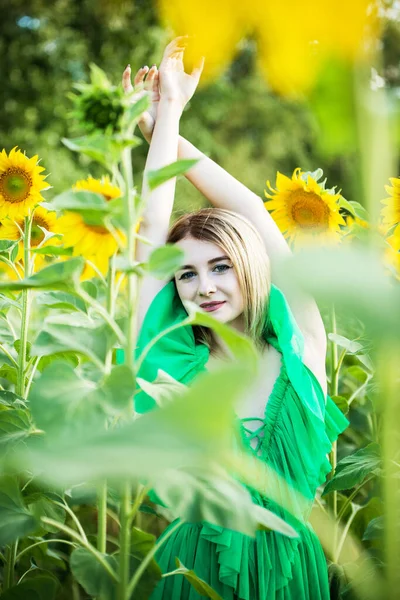 ブロンドヨーロッパの女の子で緑のドレスにひまわり ストックフォト