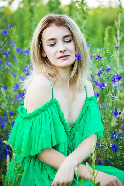 Ξανθό Ευρωπαϊκό Κορίτσι Ένα Πράσινο Φόρεμα Στη Φύση Μπλε Λουλούδια — Φωτογραφία Αρχείου