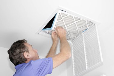 Adam kaldırma kirli hava filtresi, olgun erkek bir ev tavan hava dönüş kanalı kirli hava filtresi yaptırmayı. Bir Hvac tavan hava kanalı üzerinden bir evde iki eliyle bir kirli hava kaldırma erkek filtre.