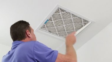 Adam yerine tavan hava filtresi olgun erkek temiz bir Hvac dönüş kanalı ile kirli hava filtresi değiştirme. Kirli hava filtresi temiz bir tavan ev hava kanalı değiştirme teknisyen.