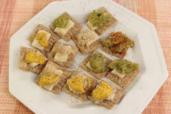 Baked Whole Wheat Crackers Topped Cheddar Cheese Guacamole Horseradish Mustard — Stock Photo, Image