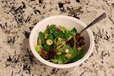 Taze bahar salatası, balzamik sirke ve sarımsaklı zeytin. Mutfak tezgahındaki balzamik sirkeli organik marul yapraklarının çeşitli çeşitleri..