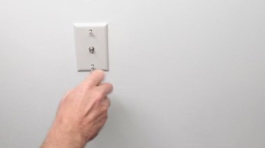 Beyaz Duvar 'da bir erkek el kablo prizinde sevişiyor. Beyaz tenli bir erkek, tornavidayla düzüşüyor. Kablolu televizyonun kapanış için beyaz bir duvar prizi. Olgun erkek eli beyaz bir duvardaki kablo prizi için üst ve alt vidaları sıkıyor.