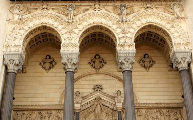 Notre Dame de Fourviere, Lyon, Fransa, Avrupa Bazilikası girişi. Yüksek sütunları, kemerleri, heykelleri ve yardım kalıpları olan tarihi binanın büyük cephesi.