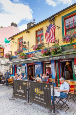 Galway, İrlanda - 18 Ağustos 2012: Erkekler rahatlatıcı dükkanı Street Galway, İrlanda Quays barda bir yaz gününde.