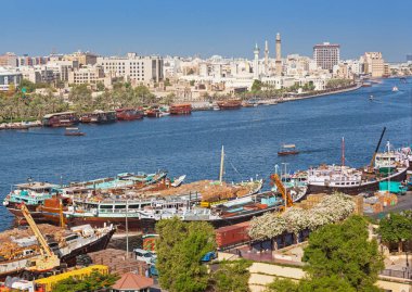Dubai, Birleşik Arap Emirlikleri - 27 Mayıs 2011: Dubai Creek, Dubai, BAE yüklenmekte olan geleneksel ahşap ticaret dhows. Eski tüccar çeyrek Bastikiya dere görülebilir.