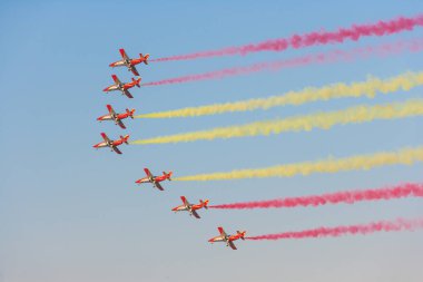 DUBAI, UAE - NOVEMBER 11, 2007: The Spanish Air Force Aerobatic Team, Patrulla Aguila (Eagle Patrol), flying at the Dubai Airshow. Flying seven Casa C-101 Aviojets, they are the only team to use yellow smoke and are also known for their formation lan clipart