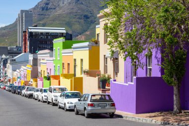 Eskiden Cape Town 'da Malay Mahallesi olarak bilinen Bo Kaap' taki Wale Caddesi 'ndeki renkli kulübelerin önüne park edilmiş arabalar.