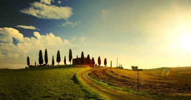tipik Tuscany kırsal manzara; tepeler ve Tuscany villag üzerinden günbatımı
