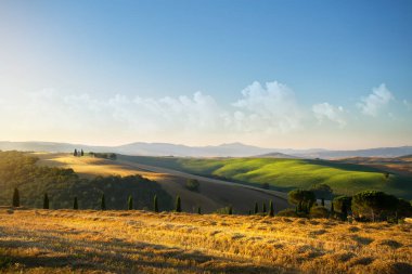 tipik Tuscany kırsal manzara; tepeler ve Tuscany villag üzerinden günbatımı