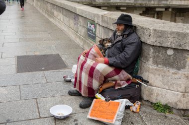 Paris, Fransa - 29 Ekim 2017: Evsiz bir adam ile bir köpek sokakta oturur ve yardım isterse. Plaka üzerinde Fransız bulunmakta: 