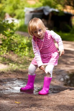 bir su birikintisi içinde küçük kız