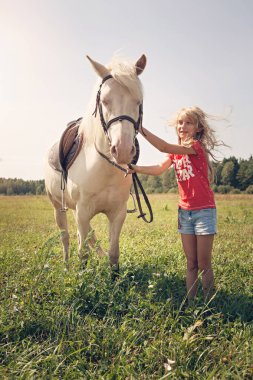 Bir genç kız ve beyaz midilli at kırsalında, Litvanya
