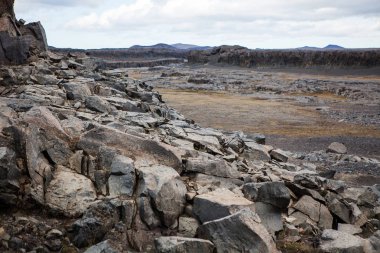 Dettifoss - Avrupa'nın en güçlü şelale yanında tipik kayalık manzara. Jokulsargljufur Milli Parkı, İzlanda. Seçici odak.