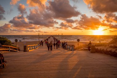Palanga, Litvanya - 12 Temmuz 2020: Turistler, tatil beldesi Palanga 'daki Baltık Denizi kıyısındaki ünlü Palanga rıhtımında gün batımını izliyorlar. 