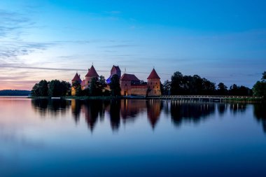 Trakai, Litvanya - 14 Temmuz 2020, gün batımından sonra Galve Gölü 'nde Trakai Kalesi. Trakai Kalesi, Litvanya 'nın başlıca turistik merkezlerinden biridir..