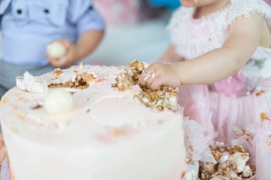 Baby's hand smashing into a cake during a first birthday celebration, a joyful tradition filled with laughter, family love, and unforgettable childhood memories