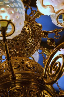 Ayrıntı bir antika süslü pirinç ve gaz ve elektrik kullanır altındaydı cam avize. 